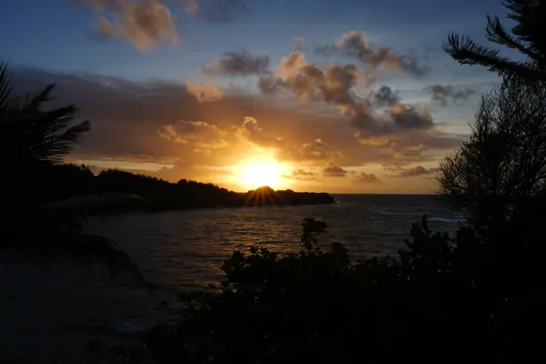 The sun setting into the sea under heavy Caribbean cloud