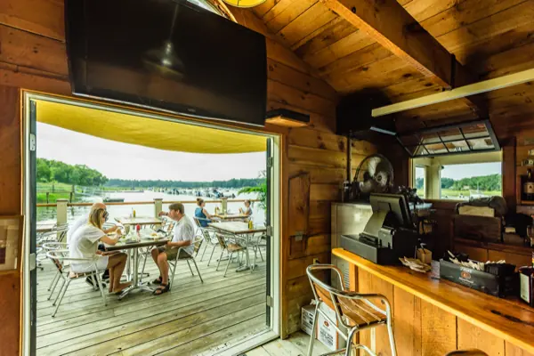 The wood-lined bar interior with its doors open onto the deck