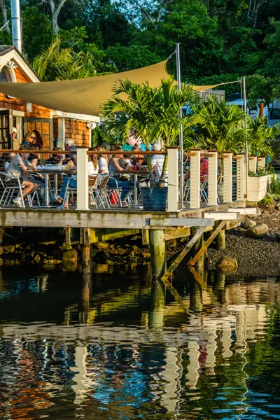 The shaded deck seen from the water, reflected in the harbor at golden hour