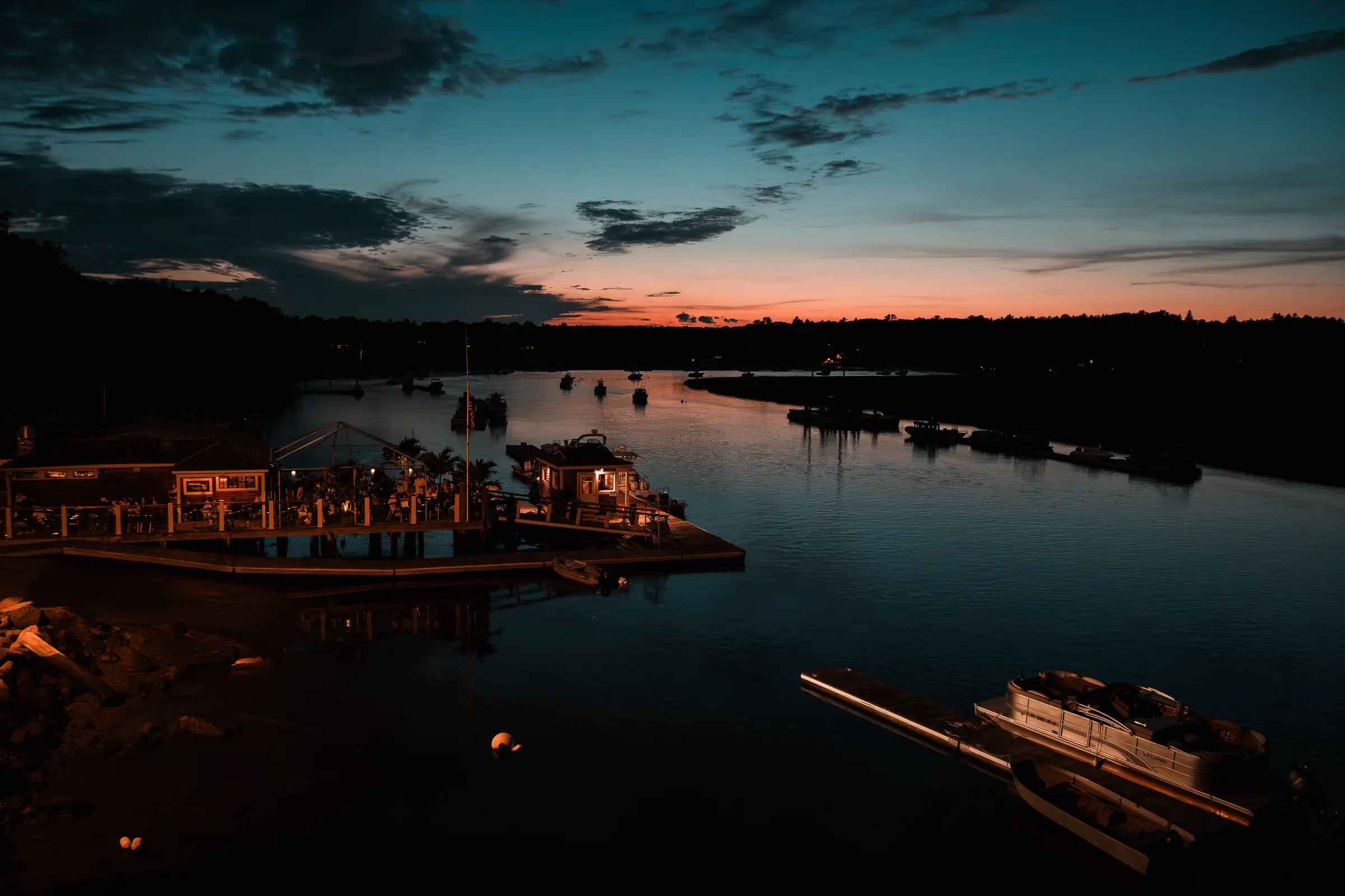 Green Harbor at blue hour, the lit boathouse reflected in still water