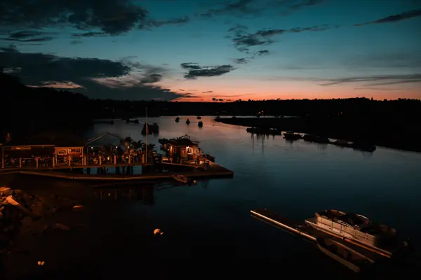 The harbor at blue hour with the boathouse lit up