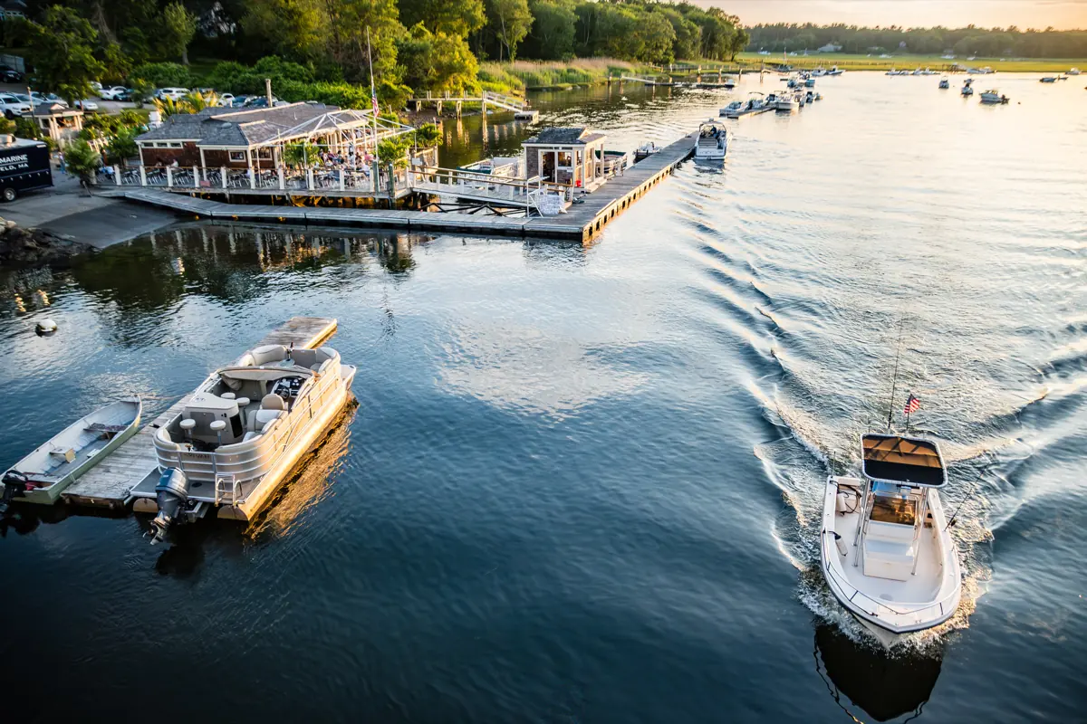 A rental boat heading out past the docks in evening light